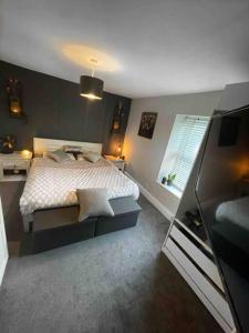 a bedroom with a bed and a television in it at Peak District Self Catering Holiday Home in Glossop
