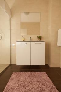 uma casa de banho com um lavatório e um tapete rosa em Apartment Juliette em Zadar