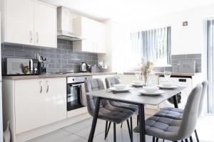 a kitchen with white cabinets and a table and chairs at Good Location Free Parking Contractor Leisure in Atherton
