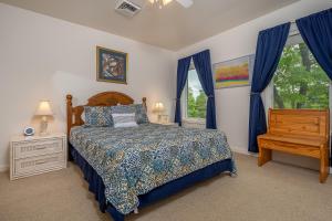 a bedroom with a bed and a window with blue curtains at Carmel Sunday in Swanton