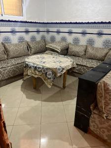 uma sala de estar com um sofá e uma mesa em شقة مفروشة مجهزة قريبة من مطار سايس em Fez