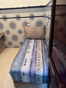 uma cama num quarto com uma parede em شقة مفروشة مجهزة قريبة من مطار سايس em Fez
