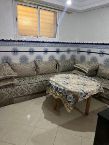 ein Wohnzimmer mit einem Sofa und einem Tisch in der Unterkunft شقة مفروشة مجهزة قريبة من مطار سايس in Fès
