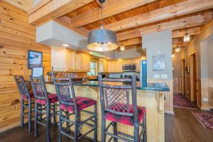 - une cuisine avec des plafonds en bois et un bar avec des tabourets dans l'établissement Bear Hollow Lodge, à Oakland