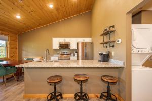 a kitchen with a counter and three stools at a counter at Base Camp in McHenry +17 photos