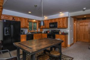 cocina con mesa de madera y nevera negra en Canopy Escape, en McHenry