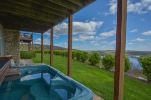 a hot tub on a porch with a view of a river at Vista Emmanuel in McHenry