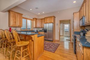 a kitchen with wooden cabinets and a island with bar stools at Vista Emmanuel in McHenry