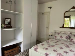 1 dormitorio con cama y espejo en Le Vetrate sul Lago Lake Como Amazing View, en Nesso