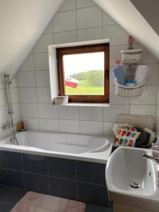een badkamer met een bad, een wastafel en een raam bij Kraina kaszubska - dom z balią kąpielową in Stare Czaple