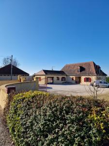 una casa con tetto di paglia e un parcheggio di GITE à BOISSE près d'ISSIGEAC 24560 DORDOGNE a Boisse