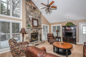 a living room with a stone fireplace and leather furniture at Black Bear Lodge in Oakland