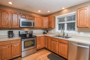 a kitchen with wooden cabinets and stainless steel appliances at Black Bear Lodge in Oakland