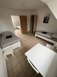 a large room with two beds and a table at Große Unterkunft für bis zu 5 Personen MG32 in Mönchengladbach +2 photos