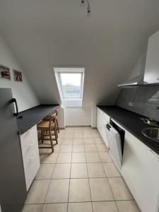 een keuken met een zwart aanrecht en een tegelvloer bij MG 32 59m² große Unterkunft für bis zu 5 Personen in Mönchengladbach