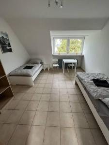 Habitación con 2 camas, mesa y ventana en MG 32 59m² große Unterkunft für bis zu 5 Personen, en Mönchengladbach