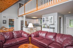 a living room with a brown leather couch and a kitchen at Take-A-Break in Oakland