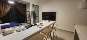 コタキナバルにあるThe Shore Ns Studio Suites Sea Viewの白いカウンター(椅子付)、ベッド1台が備わる客室です。