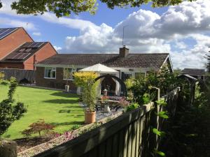 una casa con una valla y un patio en The Fields, en Worcester