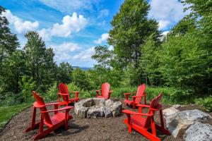 a group of red chairs sitting around a fire pit at Above it All in McHenry