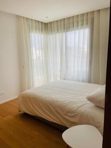 1 dormitorio con cama y ventana grande en Luxury Appt casa finance City CFC-Aeria Mall en Casablanca