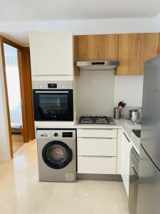 uma cozinha com um fogão e uma máquina de lavar roupa em Luxury Appt casa finance City CFC-Aeria Mall em Casablanca