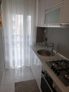 a kitchen with a sink and a counter with a stove at Home away from home - Inalpi Arena, ex Pala Alpitour apartment in Turin