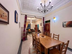 a dining room with a wooden table and chairs at Historic Rue de la Kasbah Villa in Tangier