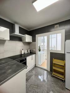 una cucina con elettrodomestici bianchi e una grande finestra di Amplio apartamento tranquilo cerca de la playa a Roses