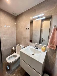 a bathroom with a sink and a toilet and a mirror at Amplio apartamento tranquilo cerca de la playa in Roses