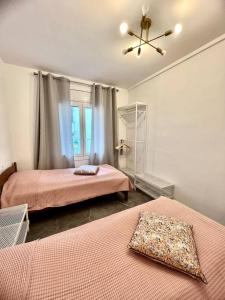een slaapkamer met 2 bedden en een plafondventilator bij Amplio apartamento tranquilo cerca de la playa in Roses