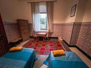 a room with two beds and a window at Historic Rue de la Kasbah Villa in Tangier