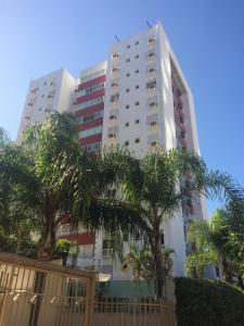 a tall white building with trees in front of it at Andy Apto Menino Deus/Cidade Baixa/Orla in Porto Alegre