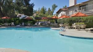 a large swimming pool with chairs and umbrellas at Riviera Oaks Resort in Ramona