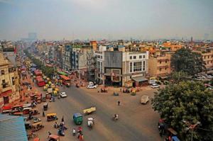una concurrida calle de la ciudad con coches, personas y edificios en Staybook Hotel Aira, Paharganj, New Delhi Railway Station, en Nueva Delhi