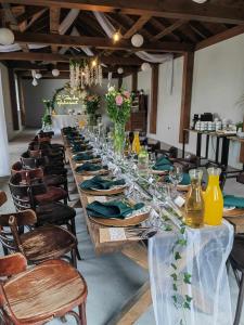 einen langen Tisch mit Tellern, Gläsern und Stühlen in der Unterkunft Mąka i Magia Obiady domowe Hotel in Zambrów