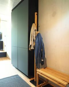 um quarto com um banco e um casaco pendurado numa parede em Holzer 2.0 em Brannenburg