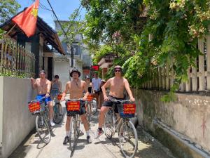 a group of men riding bikes down a street at Tam Coc Family Hotel in Ninh Binh