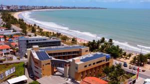 uma vista aérea da praia e dos edifícios em Bessa Beach Hotel em João Pessoa
