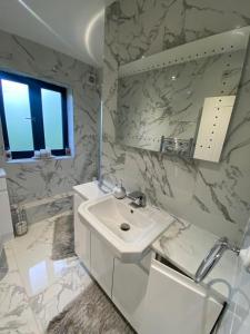 a white bathroom with a sink and a mirror at Twin/King private bedrooms in beautiful homestay with private parking in Forest Hill