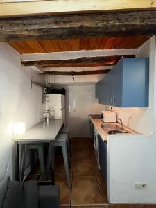 a small kitchen with a table and a refrigerator at Latina in Madrid