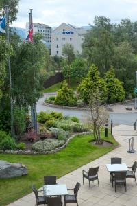 a patio with tables and chairs in a park at Macdonald Highlands Hotel at Macdonald Aviemore Resort in Aviemore