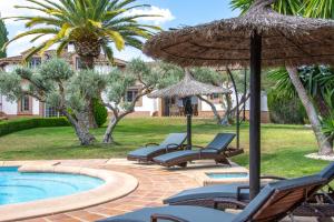 un grupo de sillas y sombrillas junto a una piscina en Andalusische Luxus-Finca, en Arriate