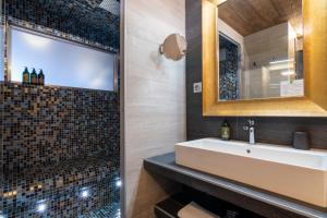 W łazience znajduje się umywalka i lustro. w obiekcie Hotel 3 Vallées Val Thorens w Val Thorens