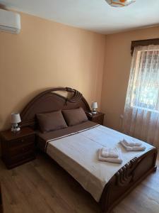 a bedroom with a large bed with two towels on it at Green House in Virpazar