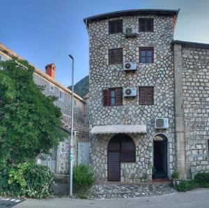 a large stone building with windows and a door at Sanja apartment in Prčanj