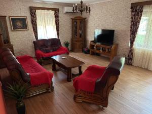 a living room with chairs and a tv and a table at Green House in Virpazar