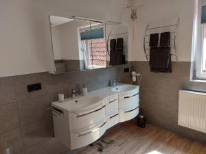 W łazience znajduje się umywalka i lustro. w obiekcie Ferienwohnung-Bergblick w mieście Bad Bocklet