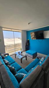a living room with blue couches and a flat screen tv at Departamento amoblado Huanchaquito in Huanchaco