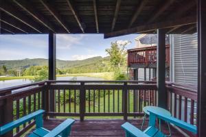 a view from the deck of a cabin with two blue chairs at Cozy Sugar Mtn Condo with AandC - Walk to Ski and Golf! in Sugar Mountain
